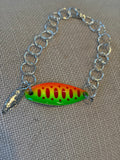 Bracelet with a colorful fishing lure charm on a textured surface