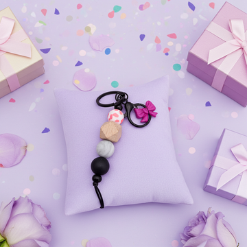 Bow Lover's Duo Bundle - Purple & Gold Bow Keychains Set against a purple background with gift boxes and flowers.