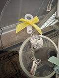 Decorative keychain with a yellow bow and 'Trust' tag on a blurred background